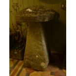 A weathered natural stone staddle stone and domed cap