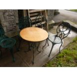 A small cast aluminium garden terrace table of circular form with decorative pierced top raised on