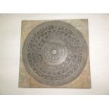 A worked soapstone plaque of squared form with incised detail of a central circular medallion