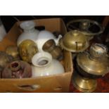 An assortment of vintage brass oil lamps and associated glass shades