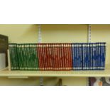 Approximately 50 volumes of classic adventures in green, red and blue bindings