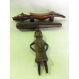 An African carved timber doll/figure in the form of a standing female depicted in a hat holding