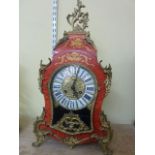 A 19th century style French bracket clock, the waisted case in timber overlaid with metallic mounts,