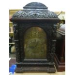 A substantial Victorian oak bracket clock, the oak case heavily carved with green man and floral,