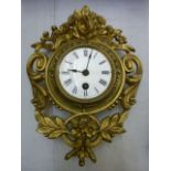 A small 19th century iron work wall clock with floral panels and further scrolled detail with