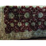 An Eastern wool rug, the red ground field with abstract floral detail within alternating borders,