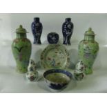 A collection of oriental ceramics including a pair of green ground vases and covers with flower vase