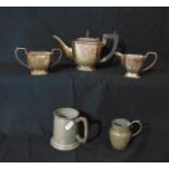 A three piece tea set comprising teapot, two handled sugar basin and milk jug, each raised on canted