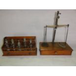 A vintage brass framed set of apothecary scales with a single draw timber base together with a