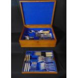 A 20th century oak canteen containing a quantity of mostly electroplated cutlery over two tiers by