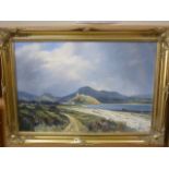 An oil painting on canvas showing an extensive coastal view in North Wales, signed bottom right W