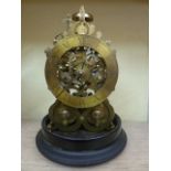 A skeleton clock with two train movement, brass dial and bell strike set beneath a glass dome on