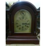 An Edwardian mahogany bracket clock , the case with arched outline and ionic column supports, the