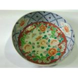 An early 20th century oriental bowl in the Imari manner with painted floral decoration to the