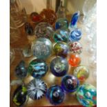 An assortment of decorative glass paperweights to include an example in the Daum manner with encased