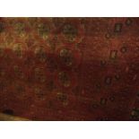 An Afghan red wool carpet, the multi medallion centre within alternating borders 320 x 200 cm