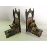 A pair of painted cast metal bookends, one in the form of a seated eastern gentleman depicted in