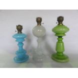 Three Victorian oil lamps, all with glass founts/stands to include an example in opaque glass of