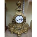 A 19th century gilded mantle clock, the case with floral swag, scroll and female bust decoration