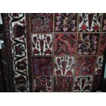 A Persian style wool carpet, the central field divided into a multitude of square panels with