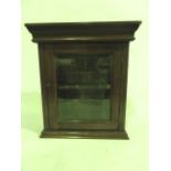 A late 19th/early 20th century small mahogany cabinet with a singular hinged panelled door fitted