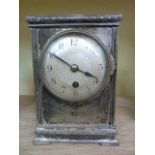 An Edwardian mantle clock in a silver plated case with engine turned dial enclosing an eight day