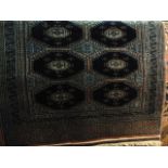 A Persian wool rug with multi-medallion panels upon a deep blue field within further blue and