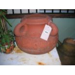 An Arts & Crafts style terracotta planter or jardinière of squat circular form with four loop