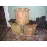 A set of three contemporary buff coloured terracotta planters of lobed quadrafoil form moulded