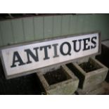 A weathered timber framed antiques sign with applied lettering 126 x 32 cm approximately