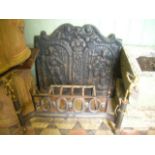 A heavy cast iron fire back with shaped outline and raised relief detail, 60 x 55 cm approximately