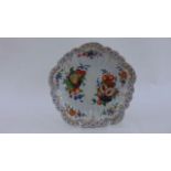 A 19th century continental low dish with hand painted floral and fruit panels within a gilded edge