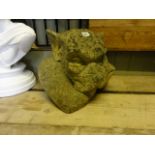 A good quality weathered contemporary cast composition stone gargoyle with head resting to one