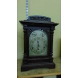 An Edwardian oak bracket clock, the case with turned and fluted columns and carved detail, enclosing