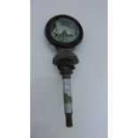 A vintage car radiator temperature indicator with original packaging