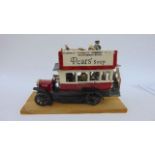 A studio ceramic model of an early Hammersmith double decker bus with passengers on board