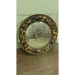 A circular mirror set in a deep relief plaster frame with trailing fruit flowers, etc with