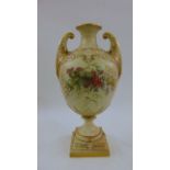 A substantial blush ivory oviform vase with open scrolled handles with hand painted floral sprays