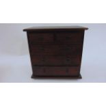 A miniature mahogany chest of three long and two short drawers in mahogany, 23 cm wide