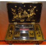 CHINESE BLACK AND GILT LAQUERED WORK TABLE WITH A HINGED TOP DIVIDING CUPBOARD AND OTHER