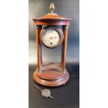 MAHOGANY FINISH FOUR PILLAR MANTLE TIME PIECE WITH A CIRCULAR DIAL, ROMAN NUMERALS, PINEAPPLE FINIAL