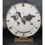 A 1960'S KIENZLE BRASS ELECTRO MECHANICLE WORLD TIME CLOCK. THE 25 cm DIAL SHOWS A MAP OF THE
