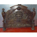 A CONTINENTAL CARVED BEECH HALF-TESTER MARRIAGE BEDSTEAD. THE ARCHED HEADBOARD WITH TWO COATS OF