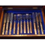 SET OF SIX SILVER PLATED FISH KNIVES AND SIX FORKS EACH WITH A JAPANESE BRONZE HANDLE WITH VARIOUS