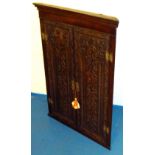 GEORGE III OAK HANGING CORNER CUPBOARD WITH TWO FLORAL CARVED PANELLED DOORS ONE DATED 1790 (103.5