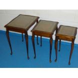 NEST OF THREE MAHOGANY FINISH TABLES WITH GILT TOOLED GREEN INSET LEATHER AND PLATE GLASS TOPS (55.5