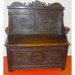 CONTINENTAL CARVED DARK OAK SETTLE WITH DOUBLE PANELLED BACK, STYLISED LION'S HEAD ARMS AND HINGED