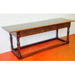 CONTINENTAL OAK REFECTORY STYLE TABLE WITH A CARVED BIRD AND FOLIATE FRIEZE ON TURNED BALUSTER