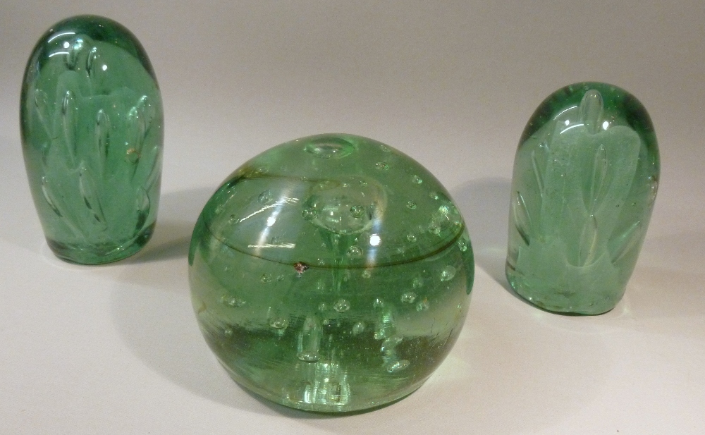 THREE VICTORIAN GREEN GLASS DUMPS TWO OF OVOID FORM WITH BUBBLES/INCLUSIONS AND A SPHERICAL DUMP