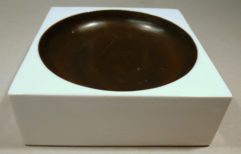 TROIKA POTTERY WHITE SQUARE ASHTRAY DECORATED BY ANN LEWIS WITH GLAZED CIRCULAR MOTIF, THE BASE WITH